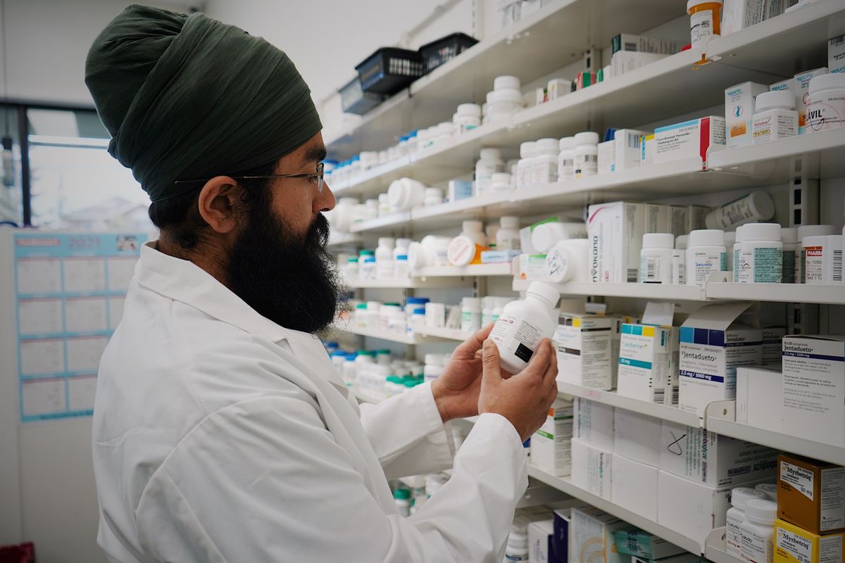 Farmacéutico seleccionando medicamentos en los estantes